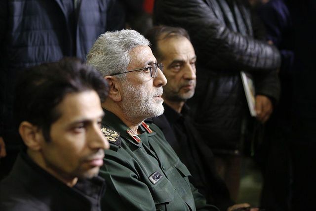 브리그장 에스마일 카아니는 2026년 2월 17일 추모식에서 두 남성 사이에 앉아 오른쪽을 바라보고 있다