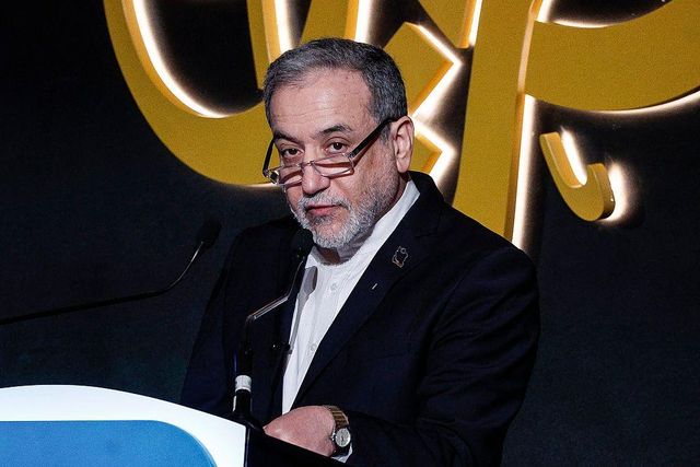 짙은 파란색 재킷과 흰 셔츠, 안경과 손목시계를 착용한 압바스 아라그치가 2026년 2월 7일 도하에서 열린 제17회 알자지라 포럼에서 연단에 서서 마이크를 향해 연설하고 있다