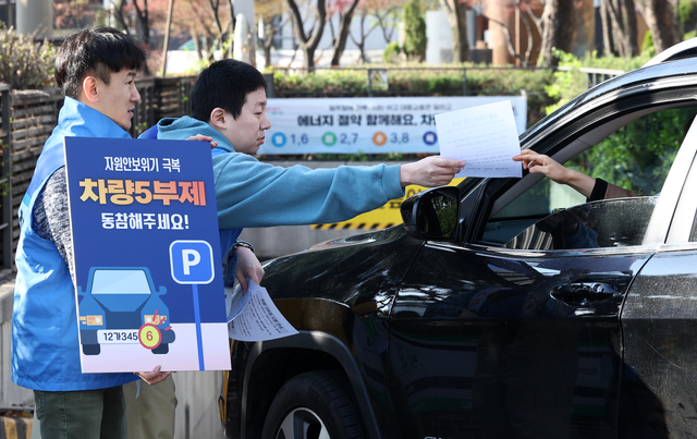 공영주차장 차량 5부제가 시행된 8일 오전 서울 종로구 세종로공영주차장에서 서울시설공단 관계자들이 주차장 이용자들에게 안내문을 배부하며 5부제 참여를 독려하고 있다. 