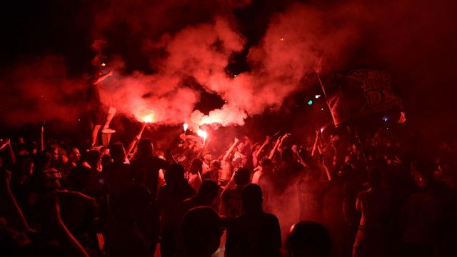 파리에서 PSG 팬들이 경찰과 충돌하는 가운데 조명탄을 터뜨리고 있다