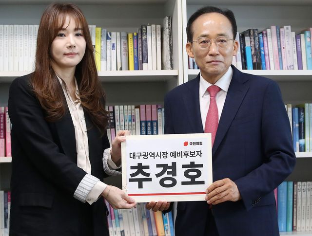 6·3 지방선거 국민의힘 대구시장 후보로 출마하는 추경호 전 의원이 30일 오전 대구시선거관리위원회를 찾아 선관위 관계자에게 예비후보 등록 서류를 전달하며 포즈를 취하고 있다