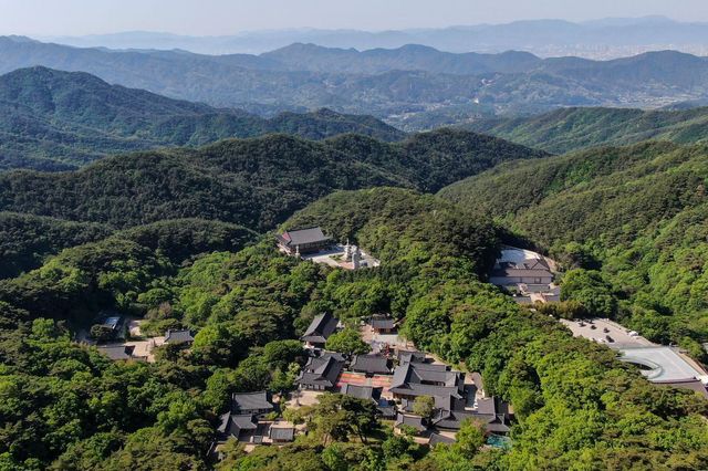 한국 대구 인근 산속의 울창한 숲으로 둘러싸인 동화사를 상공에서 내려다본 모습 