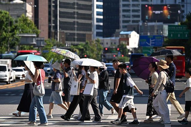 여러 무리의 사람들이 서울 시청역 인근에서 길을 건너고 있다
