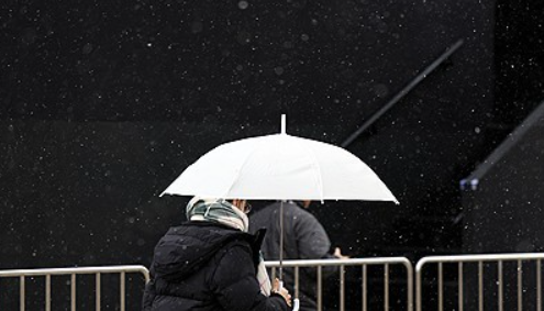 지난 17일 서울 종로구 광화문광장에 눈이 내려 시민이 우산을 쓰고 있다. ⓒ연합뉴스