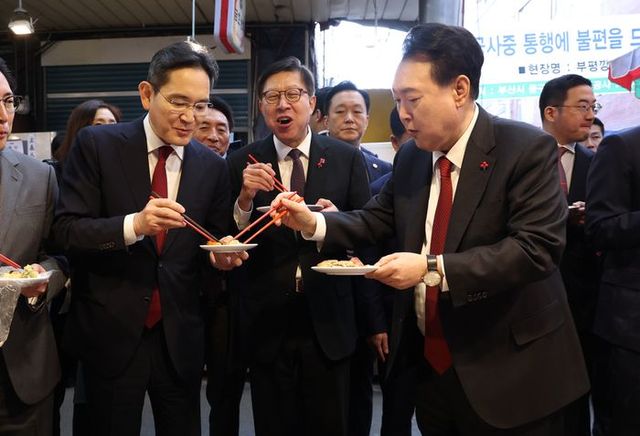 윤석열 대통령이 6일 부산 중구 깡통시장을 방문해 이재용 삼성전자 회장에게 빈대떡을 나눠주고 있다. (대통령실통신사진기자단) ⓒ뉴시스스