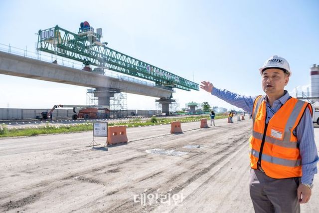 지난 19일(현지시간) 필리핀 팜팡가주 아팔랏시에 위치한 철도 교량 건설 현장에서 이용정 현대건설 현장소장이 50t의 콘크리트 세그먼트를 들어 올리는 건설 기계(초록색)에 대해 설명하고 있다. ⓒ아시아개발은행(ADB) 제공