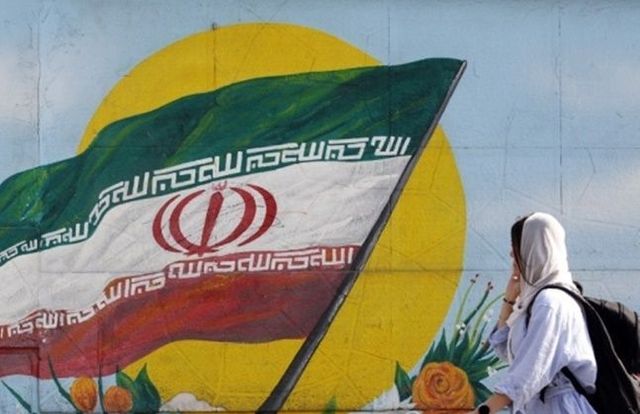 이란 여성이 이란 국기 벽화가 있는 곳을 지나가고 있다. ⓒEPA/연합뉴스