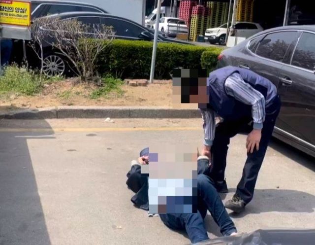 부산의 한 농산물 시장 주차장에서 다른 차가 주차하지 못하도록 바닥에 드러누워 버틴 한 여성의 사연이 온라인 커뮤니티에 전해져 화제다.ⓒ온라인 커뮤니티