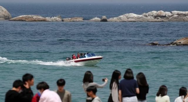 강원 강릉지역의 낮 최고기온이 34도를 훌쩍 넘은 16일 경포해변을 찾은 관광객들이 보트를 타고 시원한 바닷바람을 맞으며 무더위를 식히고 있다. ⓒ연합뉴