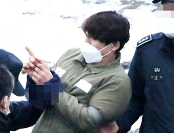 택시 기사와 동거녀를 살해한 혐의로 구속된 이기영이 6일 오후 경기도 파주 공릉천변에서 검찰 관계자들에게 시신을 매장했다고 진술한 부근을 손으로 가리키고 있다.ⓒ연합뉴스