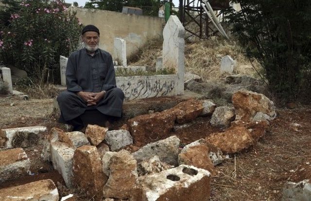 미군의 무인기 동원 알카에다 제거 활동에 사망한 시리아 북서부의 한 마을 주민 로트피 하산 미스토 씨의 가족이 그의 무덤 옆에 앉아 있다. ⓒAP/연합뉴스