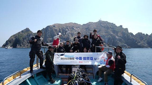 스쿠버다이빙 자격증을 소유한 임직원과 전문 강사 등이 수중 플로깅 봉사활동을 실시한 후 기념촬영하고 있다.ⓒBNK경남은행