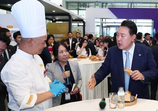 베트남을 국빈 방문한 윤석열 대통령이 22일(현지시간) 하노이 국가컨벤션센터에서 열린 한-베트남 파트너십 박람회에서 K-Food 행사장을 찾아 김치로 만든 반미 샌드위치를 시식하고 있다. (공동취재) ⓒ뉴시스
