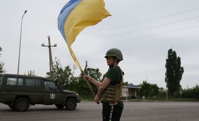 26일(현지시간) 우크라이나 도네츠크주 리만 인근 고속도로에서 한 소년이 우크라이나군 차량을 향해 국기를 흔들며 환영 인사를 건네고 있다. ⓒ AP/뉴시스