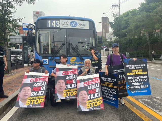 전국장애인차별철폐연대(전장연) 활동가들이 13일 오전 서울 종로구 혜화동로터리 중앙버스전용차로에서 오세훈 시장을 규탄하며 시내버스를 막아서고 있다.ⓒ연합뉴스
