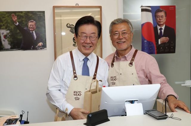 이재명 더불어민주당 대표가 지난 5월 문재인 전 대통령이 경남 양산 평산마을에 문을 연 평산책방을 찾아 계산대에서 봉사를 마친 뒤 기념사진을 찍고 있다. ⓒ뉴시스