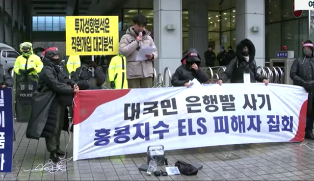 지난해 12월 15일 서울 여의도 금융감독원 앞에서 열린 홍콩지수 ELS 피해자 집회에서 한 참가자가 피해사례를 발표하고 있다. ⓒ연합뉴스TV 화면 갈무리