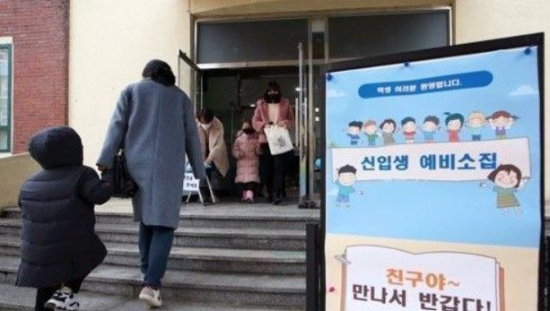 지난해 1월 4일 오후 광주의 한 초등학교에서 열린 신입생 예비소집에서 취학예정 아동이 엄마의 손을 잡고 예비소집장에 입장하고 있다.ⓒ연합뉴스