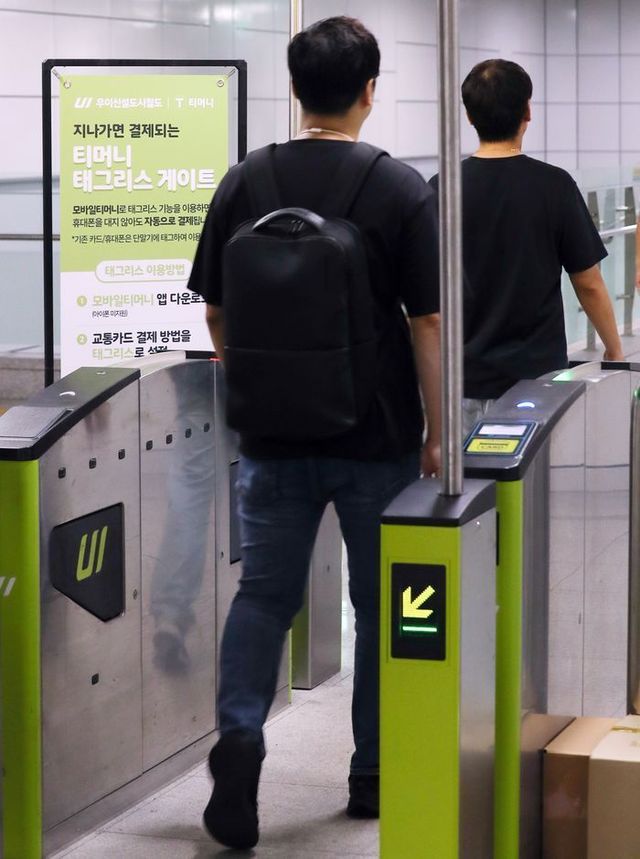 6일 서울 강북구 우이신설선 삼양사거리역에 설치된 티머니 태그리스(Tagless) 게이트에서 업체 관계자들이 스마트폰 앱 설정 후 교통카드나 스마트폰 태그 없이 개찰구를 통과하고 있다.ⓒ뉴시스