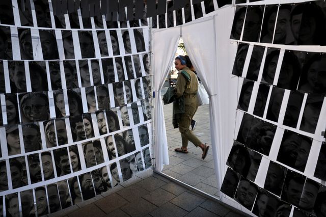 이스라엘 기업가가 팔레스타인 무장 정파 하마스에 억류됐다가 돌아온 인질과 인질을 구한 이들에게 1인당 10만달러(약 1억3695만원)를 주겠다고 약속했다. 사진은 지난 7일 하마스에 납치된 인질들의 사진을 모아둔 곳을 군인이 지나가는 모습. /사진=로이터