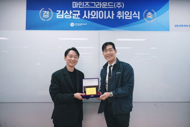 민환기 마인즈그라운드 대표(오른쪽)가 지난 21일 본사 대회의실에서 김상균 사외이사에게 취임패를 전달하고 있다. /사진=마인즈그라운드