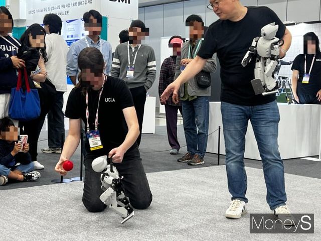 로멜라 연구소의 연구원과 데니스홍 교수가 색깔을 표적으로 움직이는 미니 로봇을 시연하고 있다. /사진=김서연 기자 