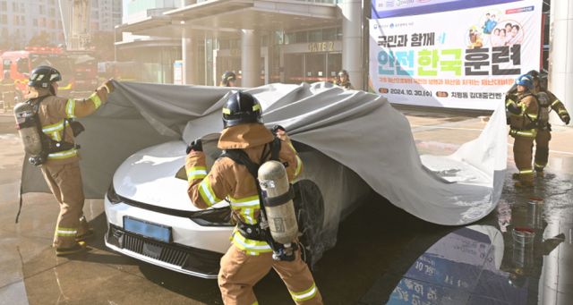 전기차 배터리 안전관리 강화를 위해 정부가 직접 나섰다. 국토교통부는 10일 내년 2월 배터리 안전성 인증제와 이력관리제 도입을 앞두고 오는 11일부터 12월23일까지 42일간 하위법령 개정안을 입법예고 한다고 밝혔다. 지난 10월30일 광주 서구에서 소방대원들이 전기차 화재 발생시 질식소화포를 덮는 훈련을 하고 있다. /사진=뉴시스