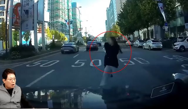 무단횡단하는 한 여성의 모습이 공개됐다. 사고가 날 뻔 했지만 여성은 아무렇지 않게 길을 건너 누리꾼들의 공분을 사고 있다. /사진=유튜브 '한문철TV' 캡쳐