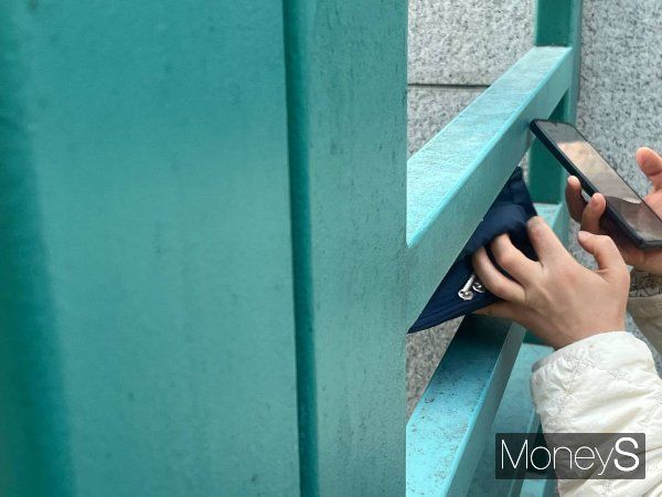 2025학년도 대학수학능력시험(수능)이 실시되는 14일 서울 중구 이화여자외국어고등학교 교문 앞 한 학부모가 도시락을 관계자를 통해 자녀에게 전달하고 있다. /사진=서혜원 기자