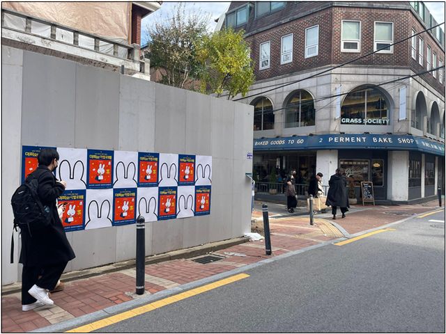 서울 성동구 성수동 일대에 미피 70주년 기념 전시를 알리는 게릴라 캠페인이 펼쳐지고 있다. 한 시민이 관련 게릴라 포스터 옆을 지나고 있다. /사진=피플리