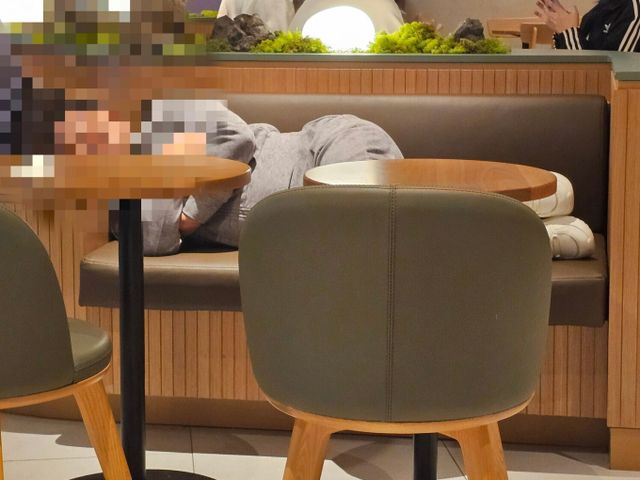 스타벅스에서 한 여성이 카페 내부 좌석에 누워 있는 모습이 포착됐다. /사진=온라인 커뮤니티 갈무리