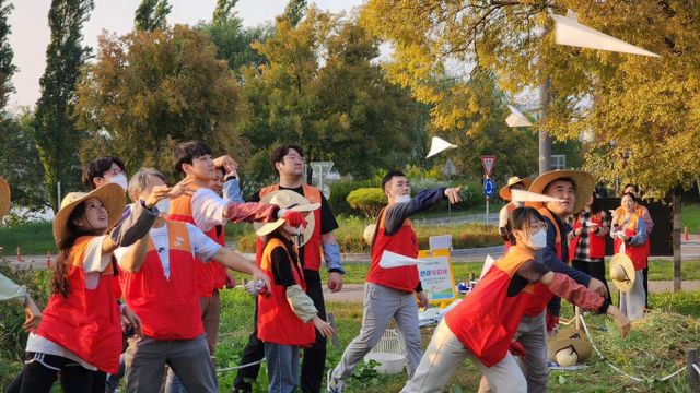 SK이노베이션 계열 구성원들이 물에 녹는 종이에 씨앗을 담은 ‘꽃씨 비행기’를 생태교란식물을 제거한 자리에 던지고 있다. /사진=SK이노베이션 