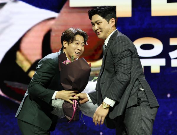  KIA 타이거즈 박찬호가 13일 오후 서울 강남구 코엑스 오디토리움에서 열린 2024 KBO 골든글러브 시상식에서 유격수 부문 골든글러브를 수상하자 LG 트윈스 유격수 오지환이 꽃다발을 전하는 모습. /사진=뉴시스 