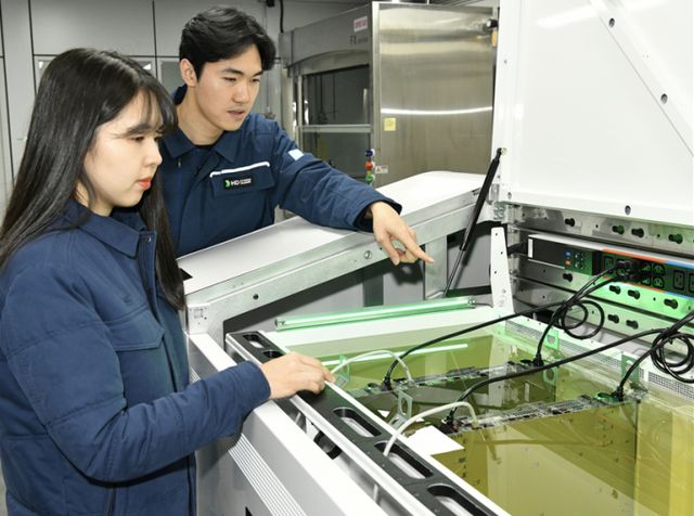 HD현대오일뱅크 직원들이 액침냉각설비에 담긴 냉각유와 서버를 테스트하고 있다. /사진=HD현대오일뱅크