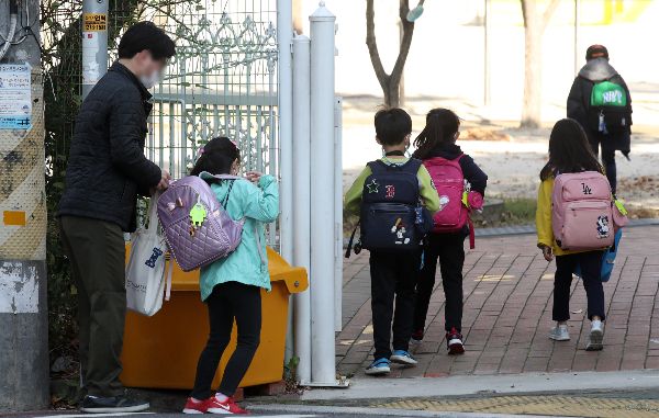 남성 100명 중 육아휴직을 사용하는 사람이 7명이 채 안 되는 가운데 정부가 남성 육아휴직 사용률을 올리겠다고 목표했다. 사진은 2020년 10월 울산 울주군 구영의 한 초등학교 앞에서 아이가 아빠와 함께 등교하는 모습. /사진=뉴스1