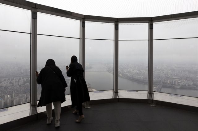 21일 날씨는 전국이 흐린 가운데 강원영동과 경상권, 제주 등에 비가 내리는 곳이 있겠다. 서울 송파구 롯데월드타워 전망대 '서울스카이'를 찾은 시민들이 구름 낀 한강 일대를 보고 있다. /사진=뉴스1