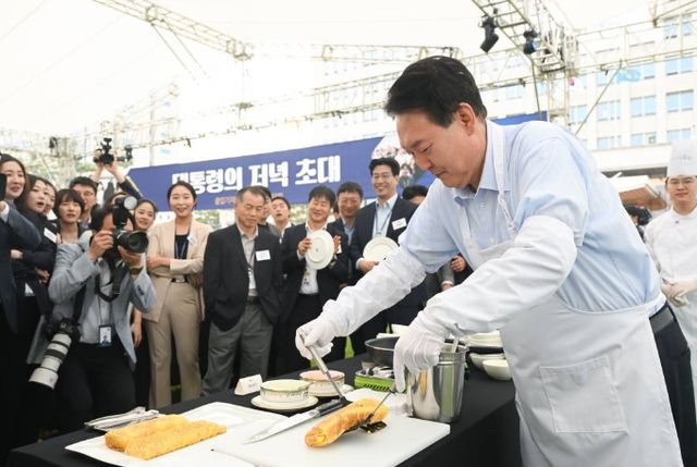 윤석열 대통령이 24일 오후 용산 대통령실 잔디마당에서 열린 출입기자단 초청 만찬 간담회에서 계란말이를 만들고 있다./사진=대통령실