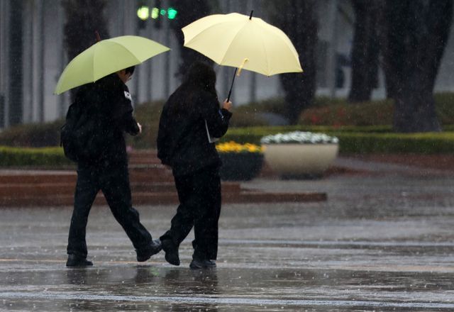 31일에는 전국에 구름이 많다가 맑아질 예정이다. 다만 밤 9시부터 다음날 오전 6시까지 수도권과 충청권에 빗방울이 내릴 것으로 보인다. 사진은 지난 3월28일 부산 해운대구 벡스코 광장에서 우산을 쓴 시민들이 발걸음을 옮기는 모습. /사진=뉴스1