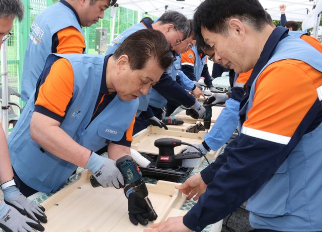 장인화 포스코그룹 회장이 임직원들과 함께 포항 대송면 제내리 마을 일대에서 도색 작업을 하고 있다. /사진=포스코그룹