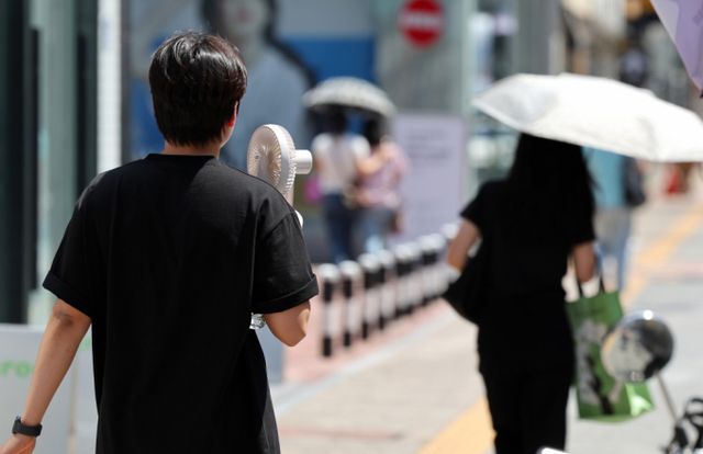  오는 14일에는 전국이 맑다가 구름 낀 날씨가 이어지겠다. 사진은 대구 낮 최고기온이 34도까지 오른 지난 12일 대구 중구 동성로에서 한 시민이 손 선풍기를 들고 이동하고 있는 모습. /사진= 뉴시스 