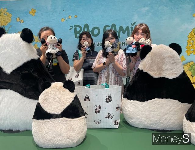 지난 21일 서울 여의도 더현대서울 5층 바오패밀리 팝업스토어에서 4050 일행이 굿즈를 들고 기념 촬영을 하고 있다. /사진=서지영 기자