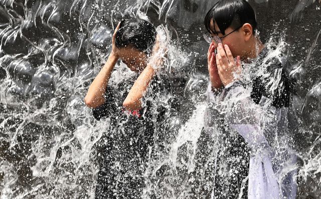 일요일인 18일에도 찜통날씨가 이어진다. 사진은 경기도 수원시 영통구 광교호수공원에 위치한 신비한 물너미를 찾은 학생들이 쏟아지는 물줄기를 맞으며 더위를 식히는 모습. /사진=뉴시스