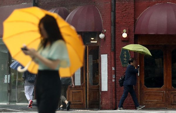 8일 전국에 무더운 날씨가 예상되는 가운데 내륙 지역을 중심으로 돌풍과 천둥·번개를 동반한 소나기나 강한 비가 내릴 전망이다. 사진은 지난 7일 서울 종로구 종각역 인근 횡단보도에서 시민들이 우산을 쓴 모습. /사진=뉴스1 