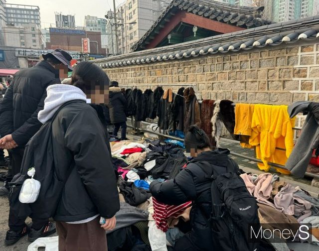 14일 오후 한 젊은 소비자가 동묘 구제시장 노점상에서 옷을 고르고 있다. /사진=정연 기자
