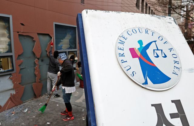  대통령 구속영장을 발부한 서부지법 앞에서 불법 집회를 열고 폭력 사태를 벌인 지지자가 회사에 잘릴 위기라며 도움을 요청했다. 사진은 윤석열 대통령 지지자들의 폭력 난입 사태가 발생한 서울서부지방법원 후문의 기울어진 법원 현판 뒤에서 관계자들이 폐기물을 치우는 모습. /사진=뉴스1