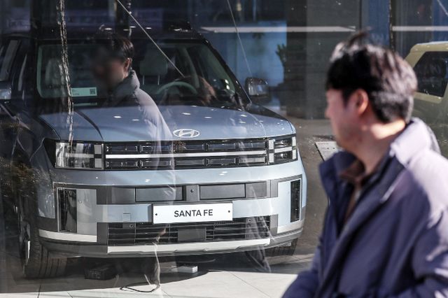 정부가 '2025년도 경제정책방향'을 발표해 자동차 개소세를 30% 낮추고 전기차 보조금 지원을 늘리기로 했다. 사진은 서울 한 자동차 영업점 앞으로 시민이 오가는 모습. /사진=뉴스1