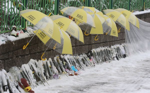 사진은 12일 대전 초등학생 피살사건이 발생한 대전 서구의 한 초등학교 정문에 추모객들이 놓고 간 국화과 편지 위에 우산이 설치돼 있는 모습. /사진=뉴스1