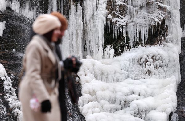 19일은 아침 기온이 영하 13도까지 떨어지는 등 겨울철 막바지 추위가 기승을 부릴 예정이다. 사진은 얼어붙은 서울 서대문구 홍제천 인공폭포 앞으로 한 시민이 지나가는 모습. /사진=뉴스1