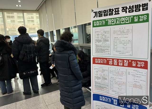 사진은 경매 게시판을 확인하는 경매참가자들 모습./사진=장동규 기자