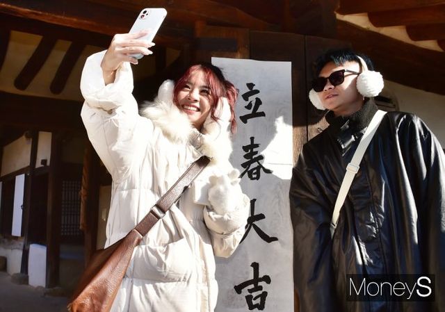 ▲ 입춘첩 앞 관광객, 올 행운·건강 내게로 오라~